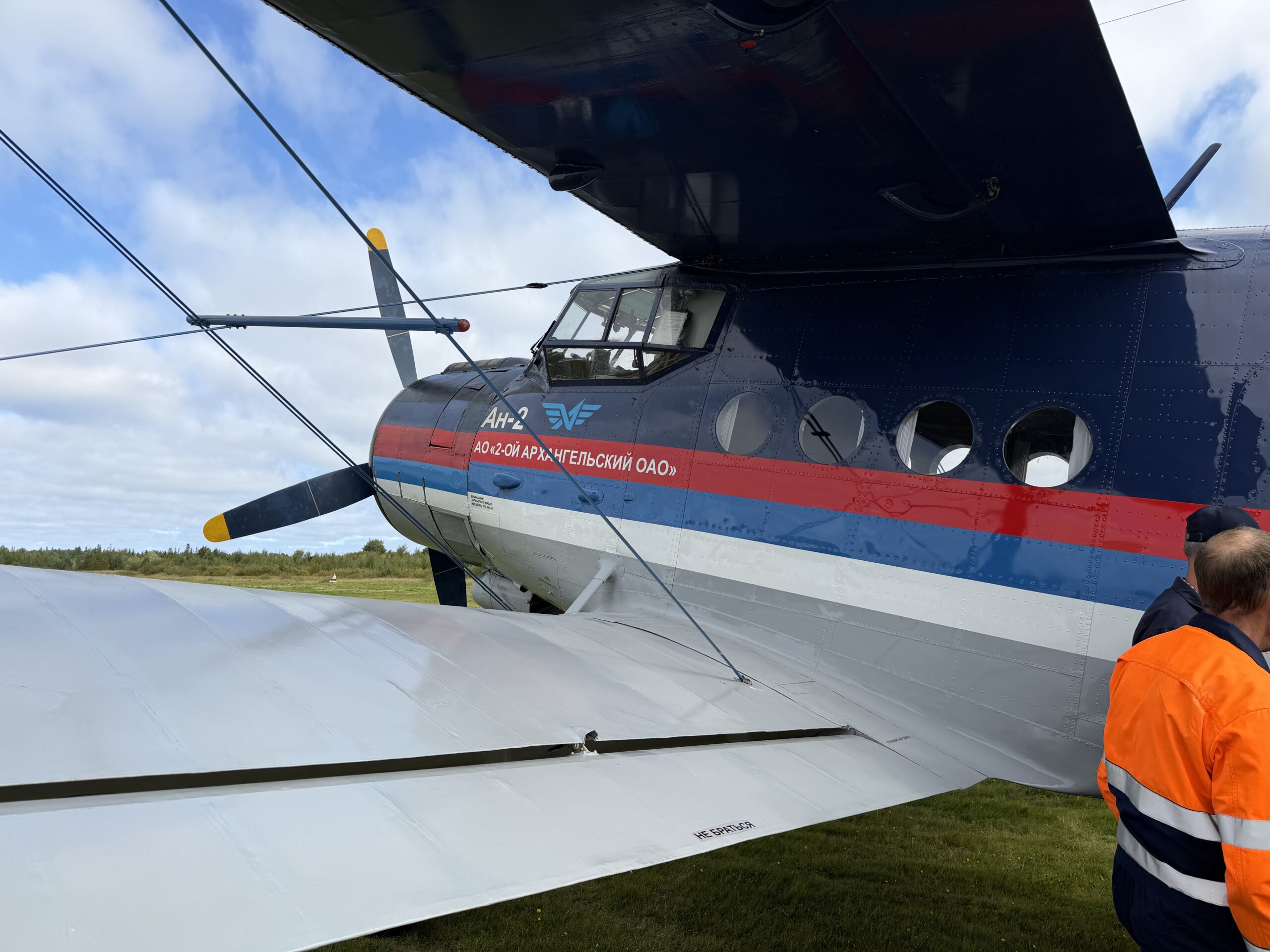 Нос и кабина Ан-2 RA-02324 с надписью «АО „2-ой Архангельский ОАО“» на борту, винт и нижнее крыло на площадке в Пертоминске