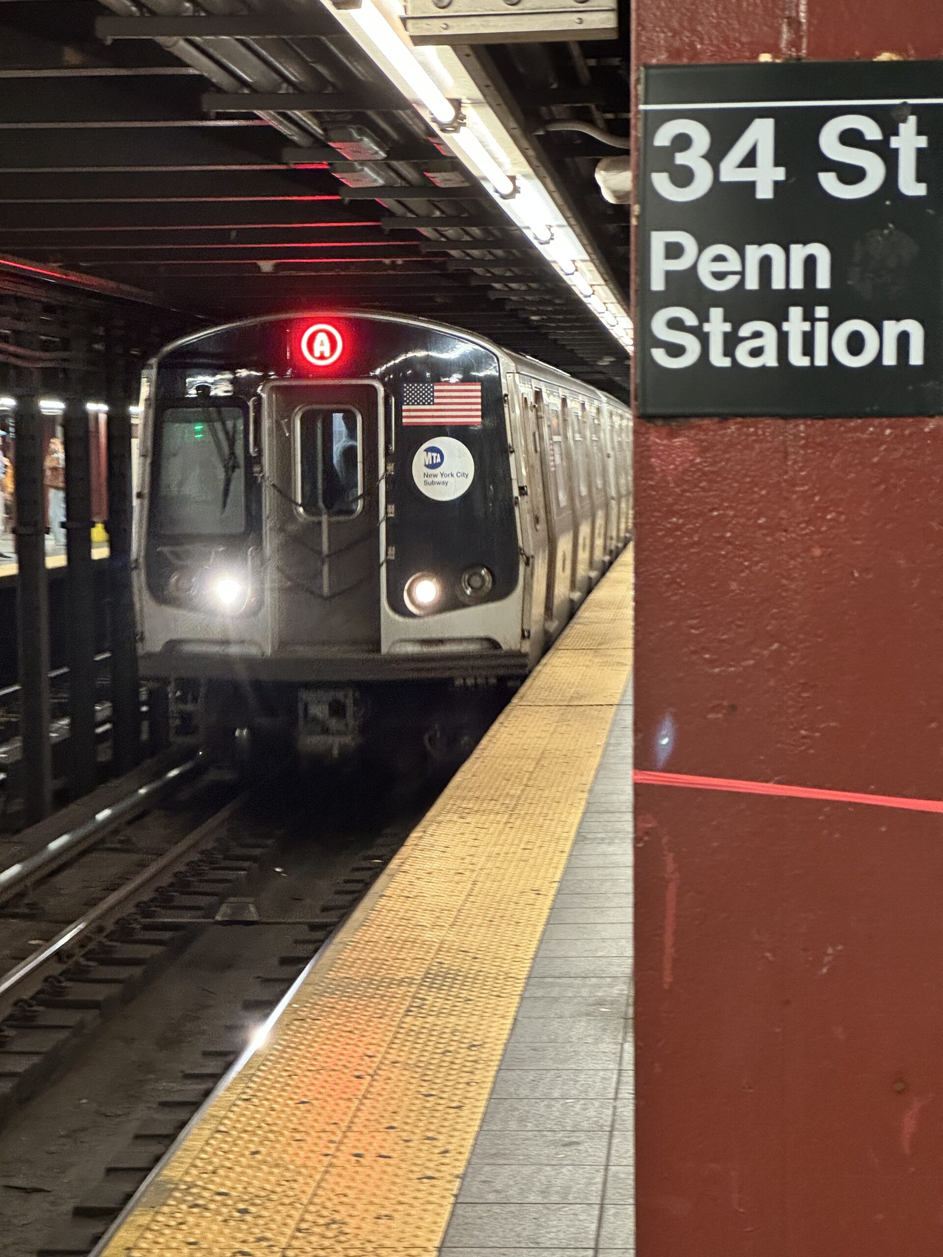 Поезд линии A на станции 34 St Penn Station в метро Нью-Йорка