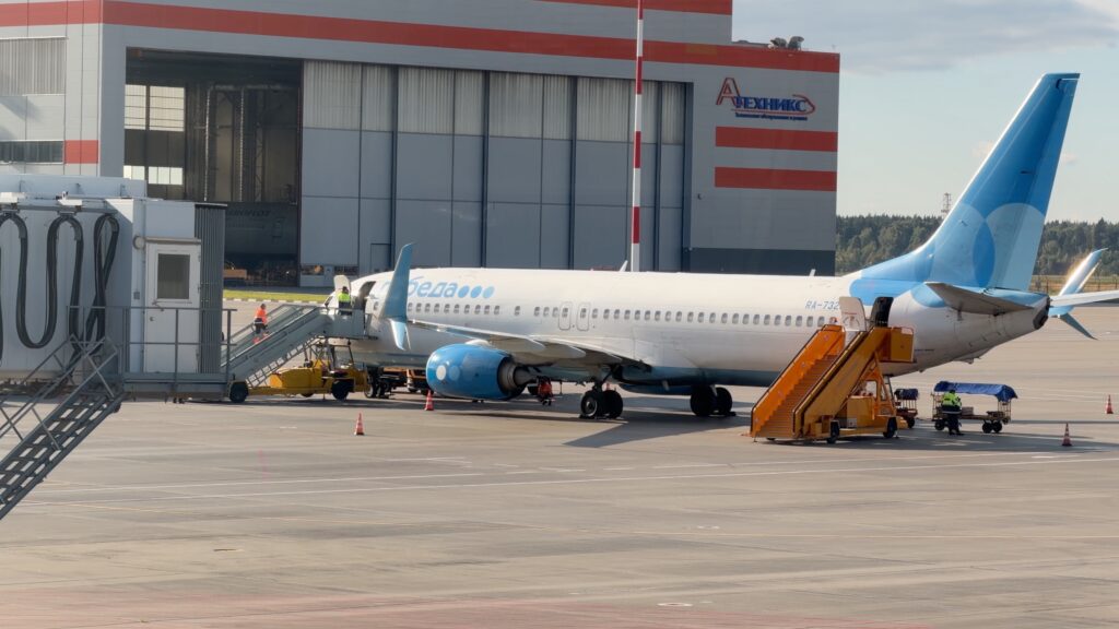 Boeing 737-800 RA-73231 авиакомпании «Победа» с трапом у передней двери перед ангаром в Шереметьево