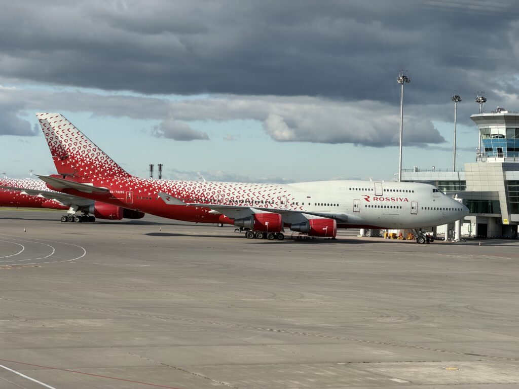 Boeing 747-400 RA-73289 авиакомпании «Россия» у телетрапа терминала D Шереметьево под тёмными облаками