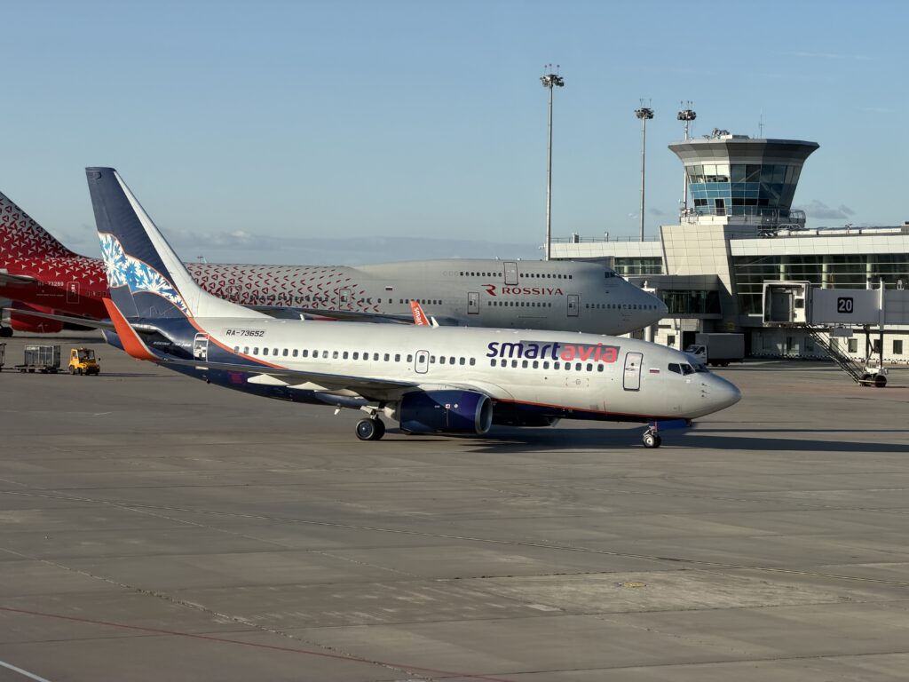 737-700 RA-73652 авиакомпании Smartavia на рулении в Шереметьево, позади Boeing 747 «России» и диспетчерская вышка